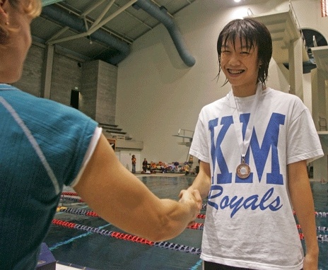 Kent-Meridian’s Joanna Wu is congratulated for a solid performance during Saturday’s Class 4A state meet.