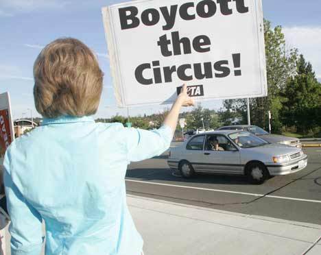 A protester with the group People for the Ethical Treatment of Animals holds up a sign Thursday outside the Kent ShoWare Center