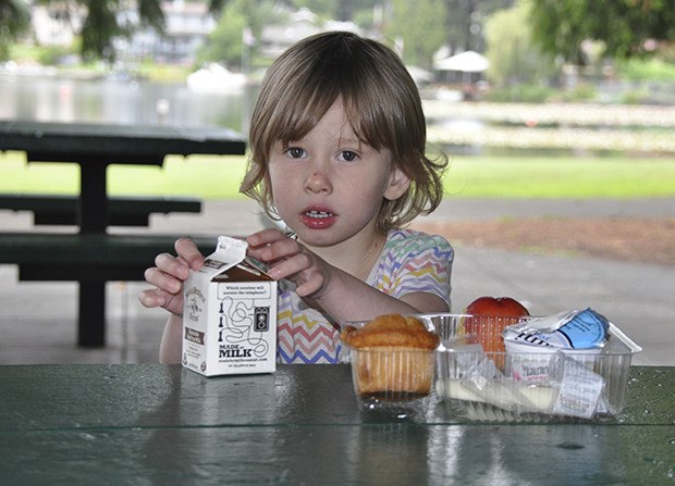 Two-year-old Jaylynn enjoys lunch at Lake Meridian Park provided by the Kent School District’s summer meal program