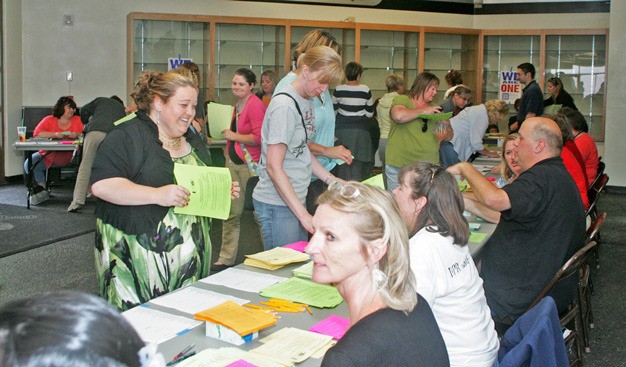 Kent teachers check in before entering the Kentwood gym Tuesday to discuss and vote on a new contract. Union members voted 97 percent in favor of a new two-year contract.