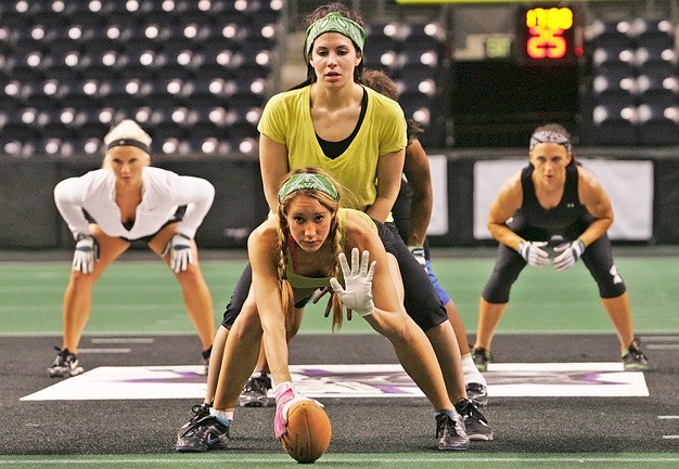 Seattle Mist quarterback Angela Rypien prepares to take a snap from center Chelsie Jorgensen at a Lingerie Football League minicamp Tuesday at the ShoWare Center in Kent.