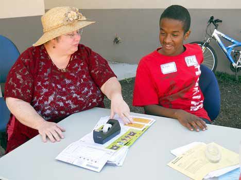 Mill Creek Middle School teacher Sharon Clark talks Aug. 24 with student Billeh Scego during orientation at the school.