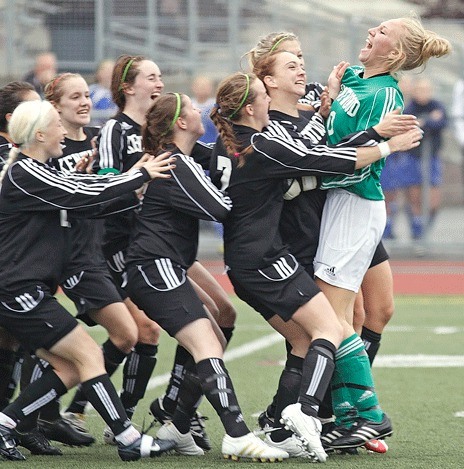 Kentwood goalkeeper Courtney Johnson is mobbed by her teammates on Saturday