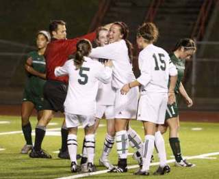 Kentwood’s Kiana Kraft gets a hug from teammate Shannon McNally after scoring last week against Beamer. The Conks open the state playoffs at 7 p.m. tonight against Shorewood at French Field.
