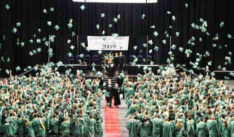 Kentridge students toss their caps into the air Saturday following their commencement ceremonies at the Kent ShoWare Center. Outgoing Superintendent Barbara Grohe is shown walking down the center aisle as the students toss their caps.