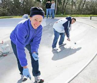 Monica Stewart and Luis Ramos cover up graffiti at West Hill Skate Park with the Kent Kiwanis Club as part of a community pride activity March 21. The city of Kent is sponsoring an art contest to help ward off graffitti at the popular skate park.