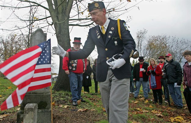 Dave Davis of the American Legion Kent Post sets the flag at the grave of a Civil War veteran in 2009 at Saar Cemetery. A dedication ceremony Sept. 6 at the cemetery will include replacement markers for four Civil War veterans.