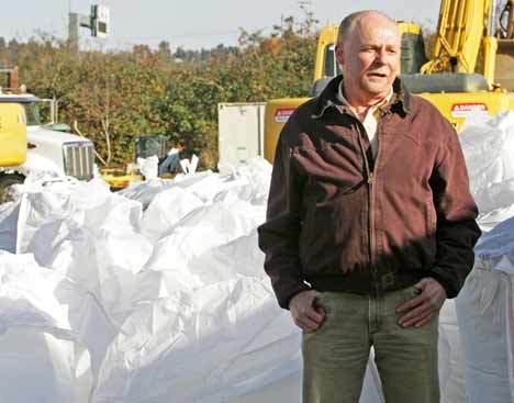 Washington State Department of Transportation Maintenance Manager Pat Moylan stands Tuesday in front of a row of giant sandbags along State Route 167 near Kent