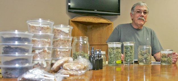 Charles Lambert displays several of the medical marijuana products at Evergreen Association of Collective Gardens in Kent.
