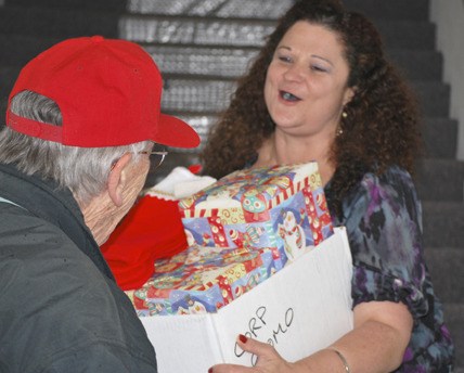 Soroptimist helper Jim Larkin delivers gifts to Sherri Curiel in downtown Kent.