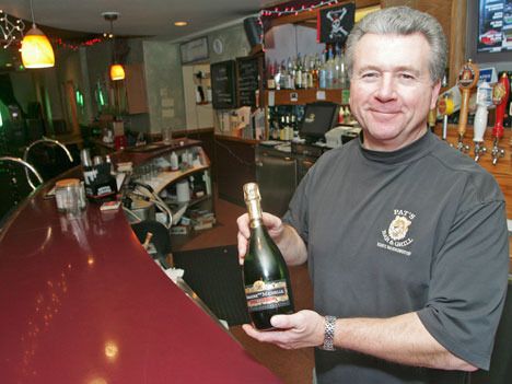 Owner of Pat's Bar and Grill Pat Ensign poses at his bar