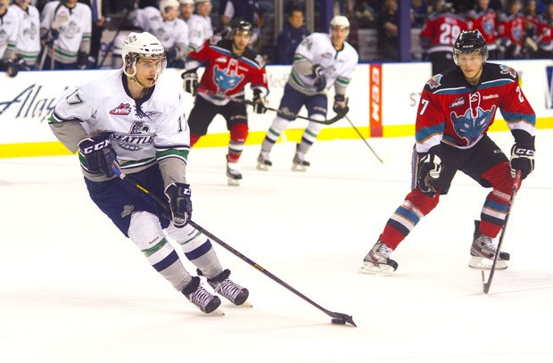 The Thunderbirds' Shea Theodore looks to pass the puck as the Rockets' Ryan Olsen pursues.