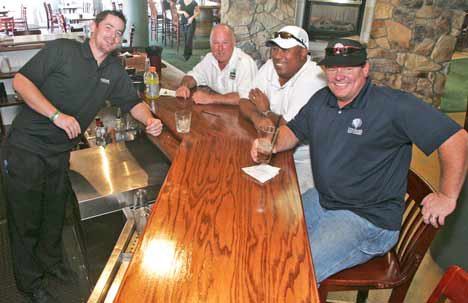 Mick Kelly's bar tender Dermot Owens serves drinks to golfers from left