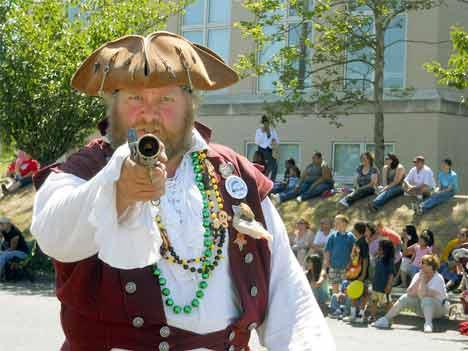 A Seafair Pirate takes aim at Sunday's Kent Cornucopia Grande Parade. He was part of a band of buccaneers creating mayhem at the annual Kent spectacle.