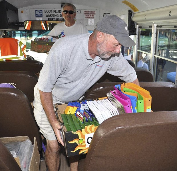 Tom Wood and Lyn Johnson put school supplies in the bus