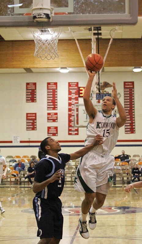 Kentwood's Jason Boyce swoops in for a bucket against Olympia on Saturday at Juanita High. The Conquerors were unable to beat the Bears and were eliminated from the Class 4A state tournament in two games.