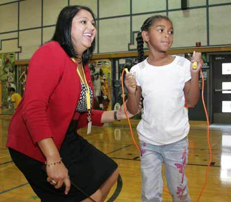 East Hill Elementary Princial Daxa Thomas speaks with second grader Nellie Rowland.