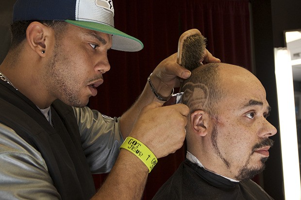 Super shave: Billy-Cory Burgans carves a Seahawks logo into Kent resident Charles Belcher’s hair on Tuesday. Belcher is one of dozens of fans who have frequented Barry’s Barber Shop on Central Avenue to get a unique styled cut in celebration of the Seahawks’ season.