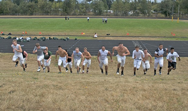 Kentridge High football players charge up a hill during a recent conditioning drill. The Chargers open the season against South Kitsap in a nonleague game at 7 p.m. Thursday