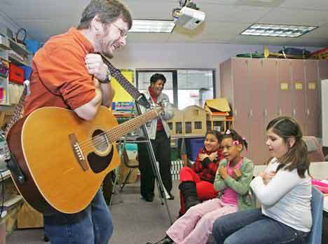 Poet Eric Ode sings and dances Daniel Elementary Principal Janet Muldrow