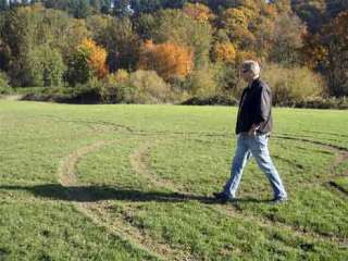 King County Parks Section Manager Don Harig examines the damage to the Kent Youth Soccer Association fields Monday.