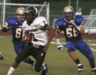 Kentwood's Mikell Everette splits the Tahoma defense for a short gain during Friday night's game.