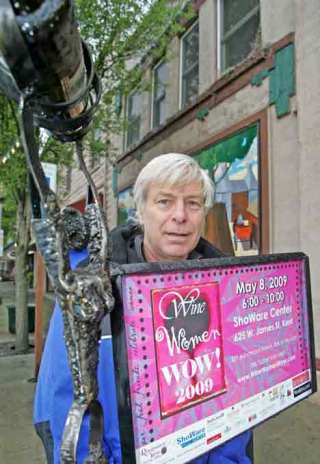 Greg Bartol poses Wednesday next to one of his signs. He’s the artist behind the downtown  metal sculptures for the “Wine Women Wow” event.