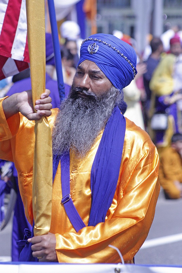 A flag bearer stands proudly at the start of the Khalsa Day Parade in 2015