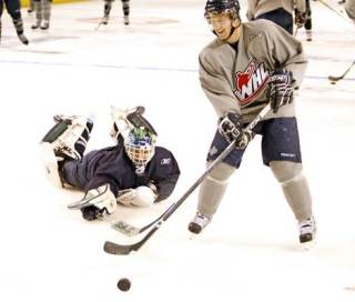 Goal tender Jacob DeSerres slides behind Forward Greg Scott