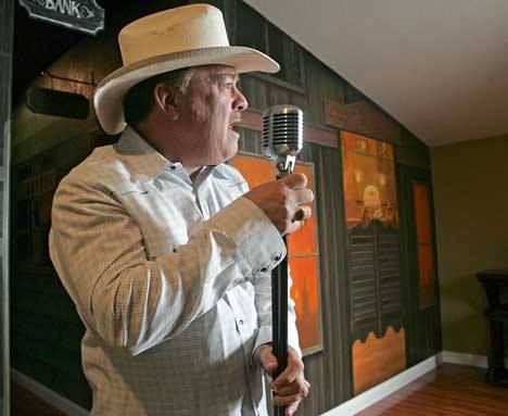 Kent resident Bobby Dean sings in his country- town themed room at his home Jan. 14.  Dean is a Kent businessman and his song “Hank On The Radio” is a top single on his newly released CD.