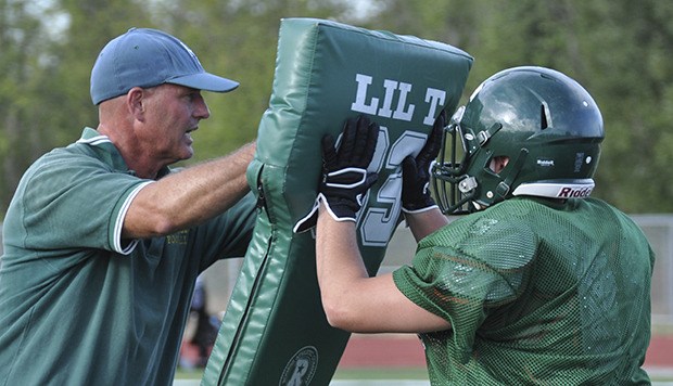Kentridge coach Marty Osborn muscles it up with a lineman during drills this week. Osborn