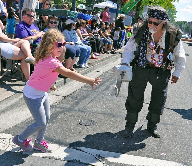 A Seafair pirate gives a sticker to Isabella Aldrich at the 2015 Kent Cornucopia Days parade. The festival runs Friday