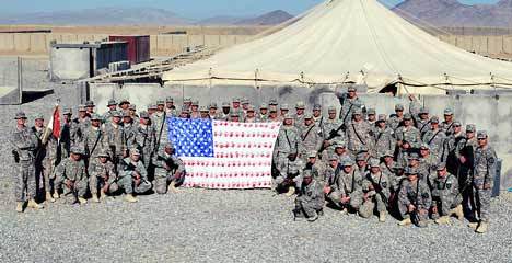 Members of the 8-1 CAV Striker Brigade out of Fort Lewis pose with the flag sent over to them by Kathryn Campbell's kindergarten class at Millennium Elementary School. Campbell's husband