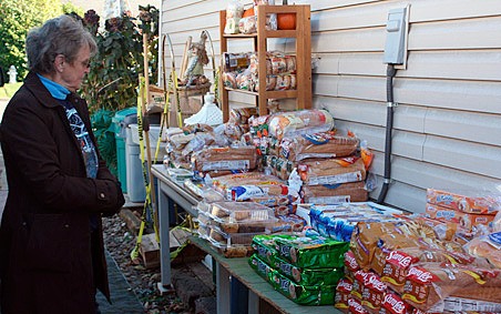 Sharon Carter checks out bakery items ready to be distributed as part of the food bank she runs out of her Kent home on the East Hill. City officials say she violates city code because of too many vehicles and pedestrians.