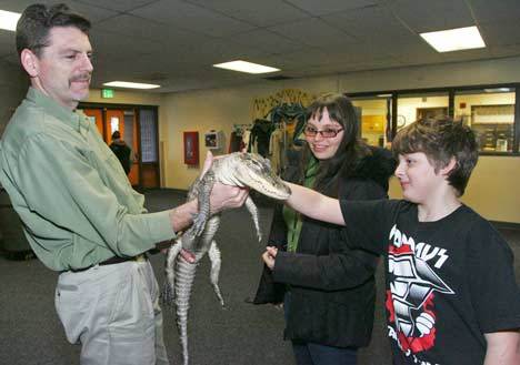 Reptile Man Scott Petersen holds up his alligator Lucy for Crestwood teacher Rachel Moore and student Bobby Dixon to pet after their school assembly Dec. 2.