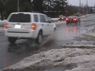 Vehicles hit puddles amid the slush Friday afternoon on 196th Avenue in Kent. Plan to see plenty more water