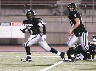 Kentwood’s Darrius Coleman (left) found plenty of room to run on Friday night