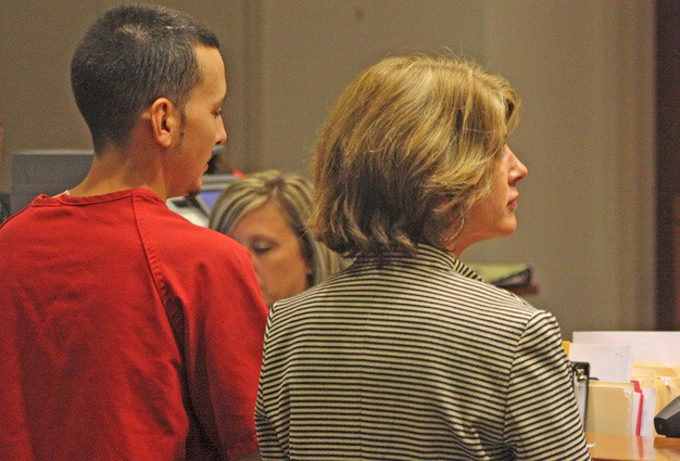 Leland D. Russell Jr. enters a not guilty plea to two counts of first-degree murder on Monday in Kent in connection with the Aug. 20 shooting deaths of two Shell station employees. Defense attorney Deborah Wilson is on the right.