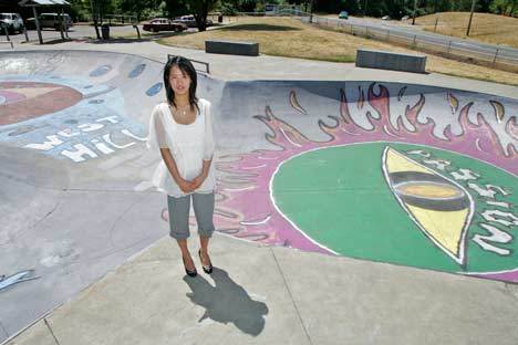 Lisa H. Park takes a moment for a photo in front of the mural she created at the West Hill Skate Park in Kent.