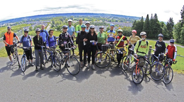 A group of riders led by the Cascade Bicycle Club stop and pose for a photo at the Robert Morris Earthwork Park last Saturday in SeaTac during the Earthworks Tour Inaugural Bike Ride. The Morris Earthwork is the highest point of the bike tour.