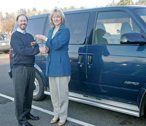 Refugee and Immigrant Service Center Director Shane Rock accepts the keys to a van from King County Councilwoman Julia Patterson Feb. 9.  The Council has donated vans to nonprofit groups to help meet their transportation needs