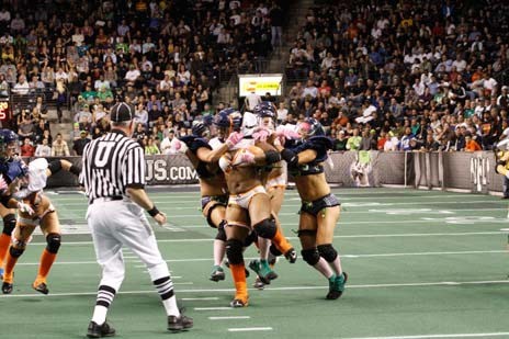 Seattle Mist players surround a Chicago Bliss player at a Lingerie Football League game Oct. 8 at the ShoWare Center in Kent.