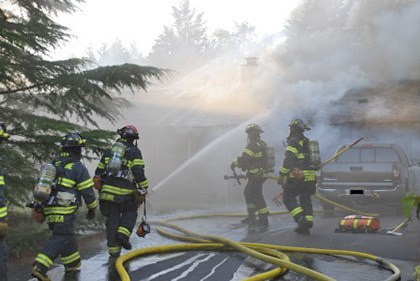Firefighters mop up a house fire in the 14300 block of Southeast 262 Street on Sunday evening.