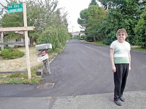 Lisa Bartholomew stands along her street