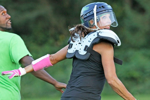 Seattle Mist receiver Jessica Hopkins looks back for a pass as she fights off assistant coach Jeremiah Captain Sept. 23 at a Lingerie Football League practice. The Mist open the season Sept. 30 at Green Bay.