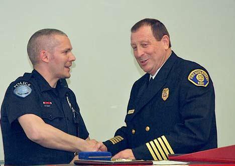Kent Police officer Kenneth Clay accepts a Kent Fire Department medal of honor from Fire Chief Jim Schneider at an April 7 ceremony. Clay helped save a resident during a fire last year.