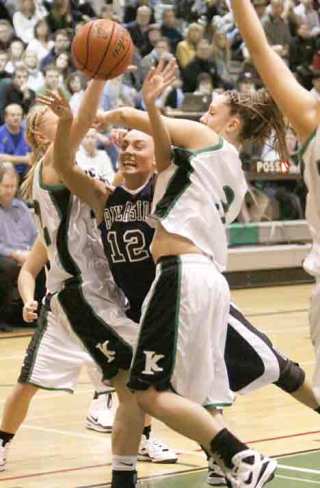 Kentwood’s Courtney Johnson (left) and Jessie Genger (right) put the squeeze on Auburn Riverside guard Amanda Thomson.