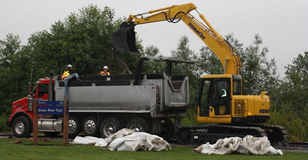 Crews begin Tuesday to remove giant sandbags from along the Green River Trail in Kent.