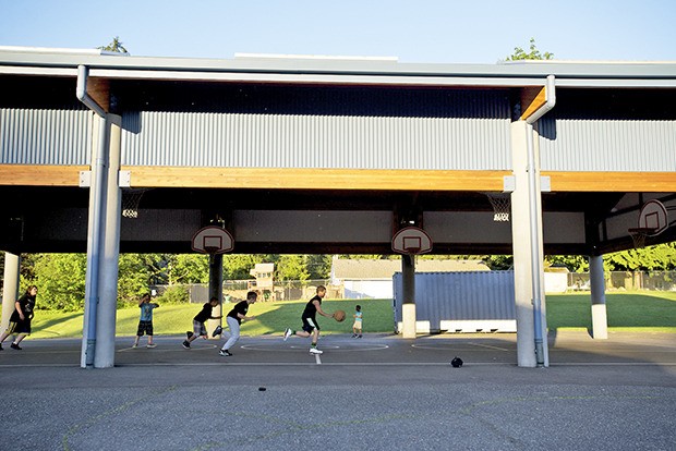 After-school light briefly illuminates a pickup basketball game at Scenic Hill Elementary School in Kent. After a weekend of mixed weather