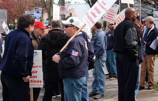 Informational pickets from the Machinists Union walk in front of Hytek Finishes March 21 in Kent to support company employees seeking a new contract.